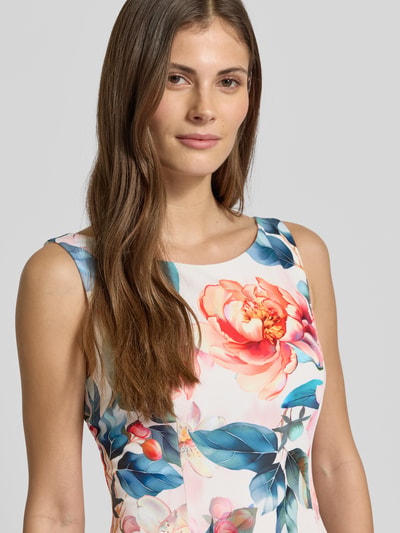 Frauenmodel trägt Cocktailkleid im Allover-Look mit gelegten Falten von Vera Mont, Material-Mix mit Stretch-Anteil, Nahaufnahme Oberkörper.
