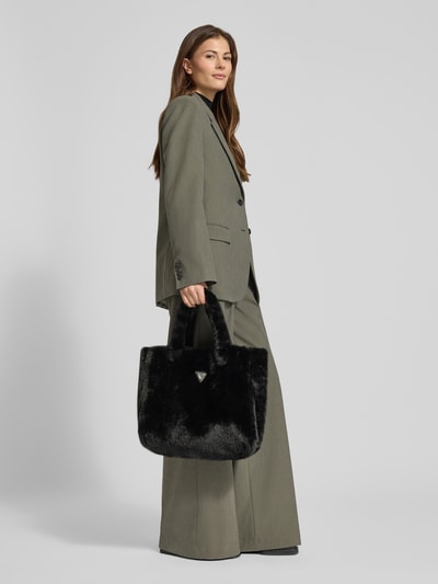Frauenmodel trägt Tote Bag aus Kunstfell Modell 'Anastasie' von Guess in Schwarz mit Logo-Applikation, Ganzkörperansicht von vorne. Damen Tote Bag mit offenem Hauptfach, Tragehenkel, Maße 42x35x13 cm, Schulterriemenlänge 45 cm.