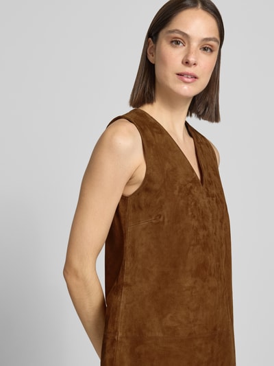 Modelka kobieca nosi Minikleid aus Leder mit V-Ausschnitt od Stefanel, brązowy kolor, prosty krój, dekolt w serek, podziałowe szwy, skóra naturalna, długość tyłu w rozmiarze 36: 83 cm, szerokość w rozmiarze 36: 44 cm, zbliżenie na górną część ciała z przodu.