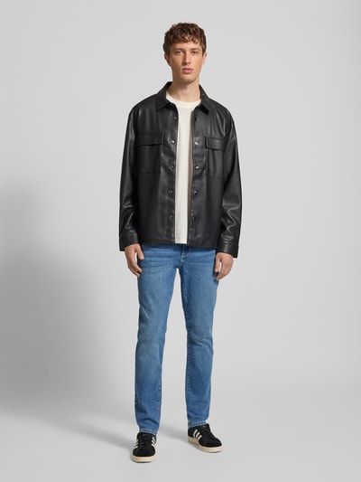Männermodel trägt Slim Fit Jeans aus Baumwoll-Mix Modell 'LOOM' von Only & Sons in mittlerem Blau, Denim-Optik, Ganzkörperansicht von vorne.