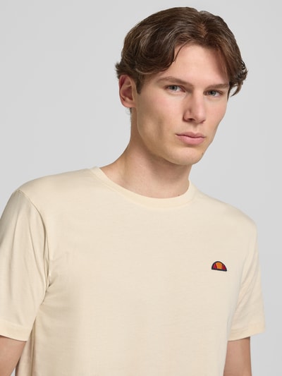Männermodel trägt ellesse T-Shirt mit Label-Stitching Modell 'CASSICA' aus Reine Baumwolle in Regular-Fit mit Rundhalsausschnitt, Nahaufnahme Oberkörper.