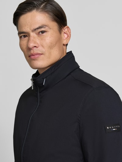 Männermodel trägt Regular Fit Jacke in Stepp-Optik von bugatti in Schwarz, glatte Textur, Nahaufnahme Oberkörper, Damen Jacke, KI-modifiziertes Bild.