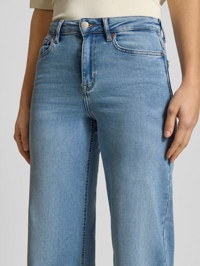 Frauenmodel trägt Jeansy z mieszanki bawełny, krój wide fit, wysoki stan, 5 kieszeni, zapięcie na guzik i zamek błyskawiczny, model 'MADISON' od ONLY, jasnoniebieski denim, detaliczna tekstura, kontekst: damskie jeansy, szerokość w pasie 38 cm, długość wewnętrzna nogawki 78 cm, widok: z przodu, zbliżenie na talię.