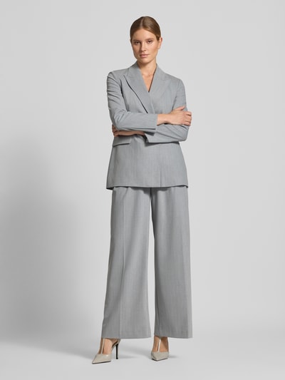 Vrouwenmodel draagt Eleganter Blazer met Bindedetail van Style Icon Collection, Materiaalmix met viscose, Slim fit, reverskraag, Klepzak, knoopsluiting met strikdetail, kleur lichtgrijs, getailleerde pasvorm, Ganzkörperansicht van voren.