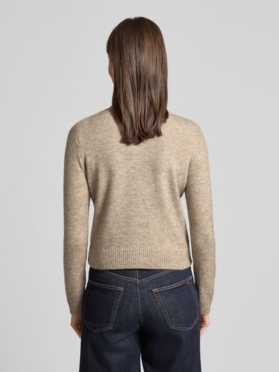 Frauenmodel trägt Regular Fit Cardigan mit Woll-Anteil Modell 'Nekka' von Mango, beigefarbener Feinstrick, elastische Abschlüsse, Ganzkörperansicht Rückansicht.