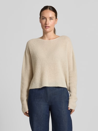 Frauenmodel trägt Strickpullover aus Alpaka-Mix Modell 'MENY' von DRYKORN, lockere Passform, beige, gerippte Textur, Ganzkörperansicht von vorne.