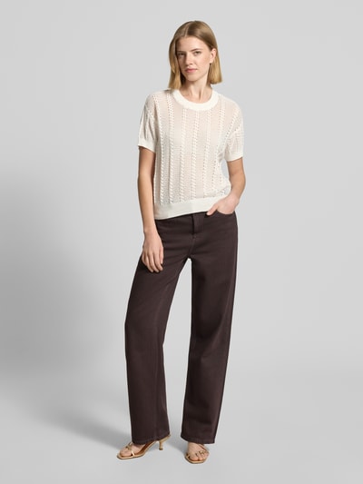 Frauenmodel trägt Relaxed Fit Strickshirt aus Baumwoll-Mix Modell 'LUX LIGHT' von Vero Moda, Optik: Unifarben, Lochstrickmuster, Rundhals, Kurzarm, gerippte Abschlüsse, Materialverarbeitung: Lochstrick, Farbe: Weiß, Textur: fein strukturiert, Ganzkörperansicht von vorne.