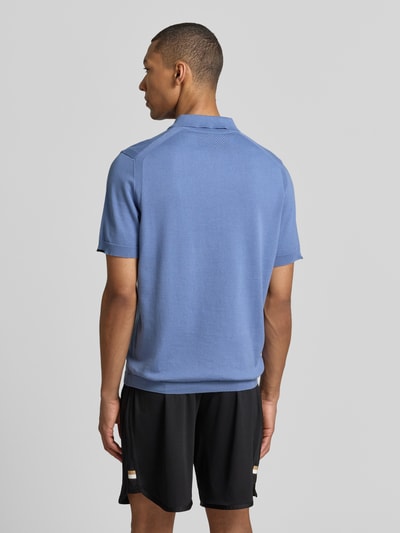 Männermodel trägt Regular Fit Poloshirt aus reiner Baumwolle Modell 'KN_EVER-X' von BOSS Green in Blau, Feinstrick, Unifarben, Ganzkörperansicht Rückansicht.