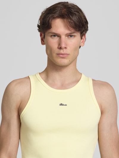 Männermodel trägt Tanktop in Ripp-Optik mit Label-Stitching von BLKVIS, Slim-Fit, Rundhalsausschnitt, Hellgelb, Nahaufnahme Oberkörper. Rückenlänge bei Größe M: 64 cm.