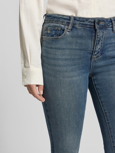 Frauenmodel trägt Skinny Fit Jeans mit Viskose-Anteil von Armani Exchange in Blau mit 5-Pocket-Design, Nahaufnahme Oberkörper, elastischer Baumwoll-Viskose-Mix, Knopf- und Reißverschluss.