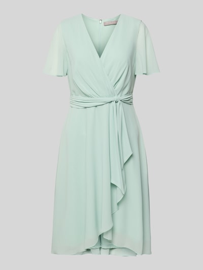Produktfoto, Knielanges Cocktailkleid in Wickel-Optik von Christian Berg Cocktail in hellgrünem Chiffon, A-Linie, V-Ausschnitt, Bindegürtel, sanfte fließende Textur