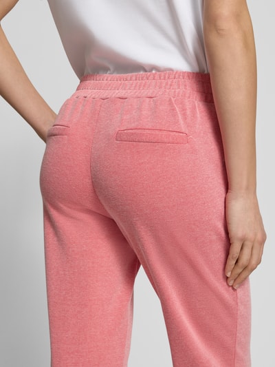Frauenmodel trägt Slim Fit Stoffhose mit elastischem Bund Modell 'Kate' von ICHI in Rosa, Baumwoll-Mix, Paspeltaschen, Nahaufnahme Rückansicht.