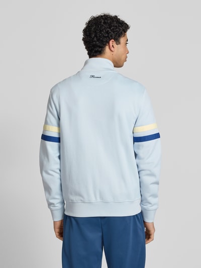Männermodel trägt Sweatjacke aus Baumwoll-Mix Modell 'ROMA' von Ellesse, Hellblau mit blauen und gelben Streifen, Gerade Passform, Rückenlänge 70 cm, Ärmellänge 68 cm, Ganzkörperansicht Rückansicht.