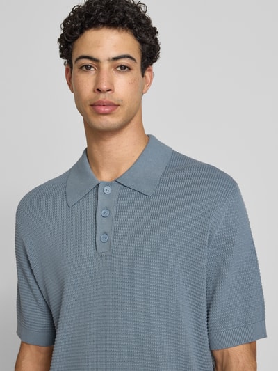 Mannenmodel draagt Regular Fit poloshirt uit puur katoen van Marc O'Polo Denim in effen kleuren, strick, labelpatch, v-hals, korte mouw, geribd; nahaufnahme bovenlichaam.