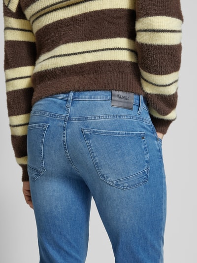 Frauenmodel trägt Slim Fit Jeans mit Eingrifftaschen Modell 'Chuck' von BRAX, Baumwoll-Elasthan-Mix, mittelblau, Detailaufnahme Rückansicht.