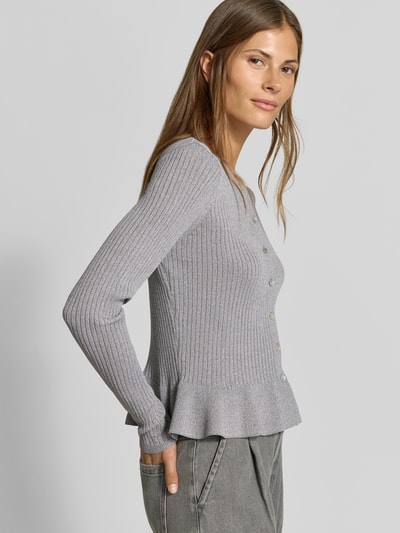 Frauenmodel trägt Strickjacke aus Viskose-Mix von MYON in Hellgrau, Ripp-Optik, Rüschenbund, körpernahe Passform, Nahaufnahme Oberkörper.