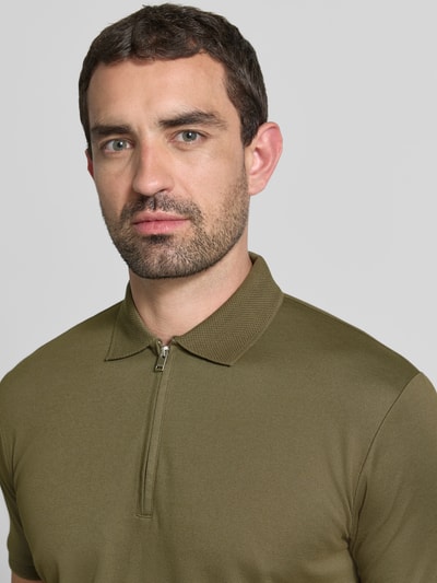 Mannermodel draagt Regular fit poloshirt uit katoenmix model 'FAVE' van Selected Homme in olijfgroen, Nahaufnahme bovenlichaam. Heren poloshirt van Selected Homme