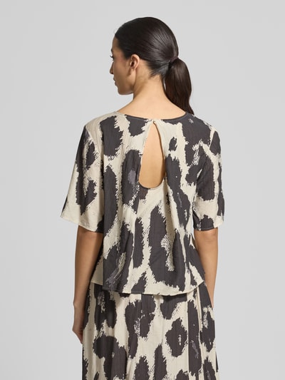Frauenmodel trägt Blusenshirt aus Viskose-Mix Modell 'Karalie Jusia' von MSCH Copenhagen, abstraktes Muster in Schwarz und Beige, Ganzkörperansicht Rückansicht.