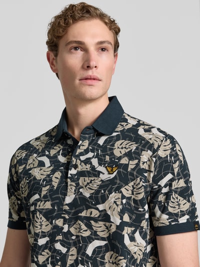 Männermodel trägt Slim Fit Poloshirt im Allover-Look von PME Legend aus Baumwoll-Elasthan-Mix, Label-Stitching, Nahaufnahme Oberkörper.