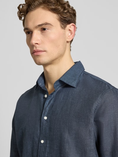 Mannelijk model draagt Regular Fit vrijetijdsoverhemd uit linnenmix van Jake*s, mix van katoen en linnen, kentkraag, knoopsluiting, ruglengte maat M 75 cm, schouderbreedte 50 cm, mouwlengte 66 cm, donkerblauw, zichtbare textuur, nahaufnahme bovenlichaam