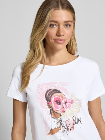 Frauenmodel trägt Regular Fit T-Shirt mit Motiv-Print von More & More aus elastischem Baumwoll-Mix, Weiß, Pailetten, Nahaufnahme Oberkörper.