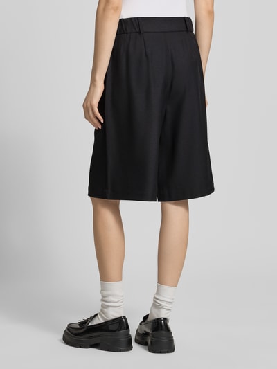 Frauenmodel trägt Regular Fit Bermudas mit Bundfalte Modell 'LINDA' von Only in schwarzer Melange-Optik, Longline-Länge, Ganzkörperansicht Rückansicht.