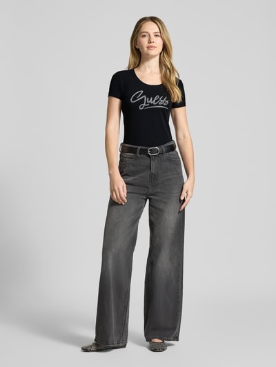 Vrouwenmodel draagt Slim Fit T-shirt met strass-steentjes van Guess in zwart, katoenmix, logodetail, ronde hals, ruglengte 60 cm, geheelvooraanzicht