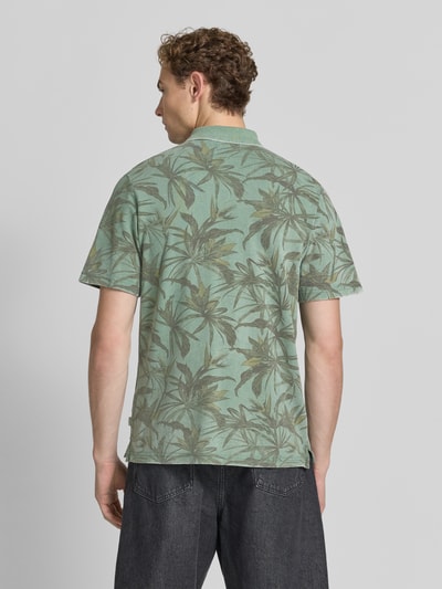 Męski model nosi Regular Fit Poloshirt mit floralem Allover-Print Modell 'Hawaii' von JACK & JONES Premium, bawełna, krój regular fit, zielone liściaste nadruki, koszulka polo z krótkim rękawem, długość tyłu w rozmiarze M: 68 cm, widok całej sylwetki z tyłu.