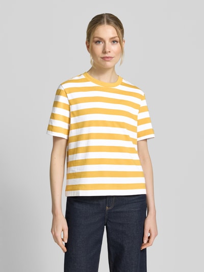 Frauenmodel trägt Boxy Fit T-Shirt aus reiner Baumwolle Modell 'ESSENTIAL' von Selected Femme, Optik:Allover-Muster, gestreift, Label-Patch, Rundhals, Kurzarm, Materialverarbeitung: heavy Jersey, Farbe Gelb-Weiß, Ganzkörperansicht von vorne.