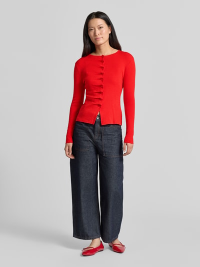 Vrouwenmodel draagt een rode mouwloos vest Model 'GAMIRA' van SUNCOO PARIS, Materiaalmix met linnen, slim fit, ronde hals, plooien, knoopsluiting, ruglengte maat S 56 cm, mouwlengte maat S 61 cm, full body vooraanzicht.