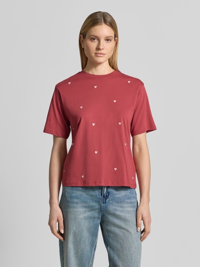 Modelka kobieca ma na sobie T-Shirt mit 1/2-Arm od Jake*s Casual z czystej bawełny, luźny krój, okrągły dekolt, długość pleców w rozmiarze S: 55 cm, kolor czerwony z białymi serduszkami, widok całej sylwetki z przodu.