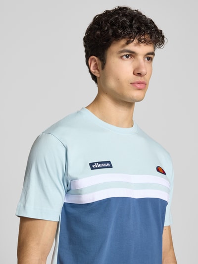 Männermodel trägt T-Shirt mit Label-Stitchings Modell 'VENIRE' von Ellesse in Blau und Weiß, Reine Baumwolle, Regular-Fit, Nahaufnahme Oberkörper.