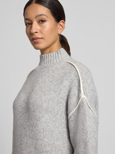 Frauenmodel trägt Regular Fit Strickkleid mit Kontraststreifen von VERO MODA, graue Strickoptik, Mock Neck, Nahaufnahme Oberkörper.