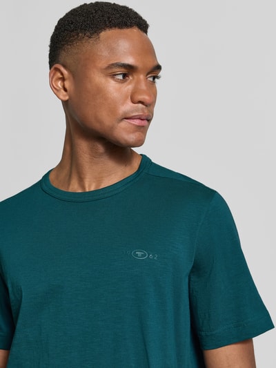 Męski model nosi Regular Fit T-Shirt aus reiner Baumwolle von Tom Tailor, optyka melanż, krój regular fit, okrągły dekolt, krótki rękaw, czysta bawełna, Nahaufnahme górnej części ciała.