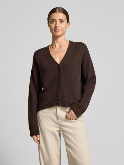Vrouwenmodel draagt Relaxed Fit Strickjacke aus Baumwoll-Mix mit Viskose-Anteil van Milano Italy, bruin, geribbelde glitter-boorden, knoopsluiting, beige broek, Ganzkörperansicht van voren.