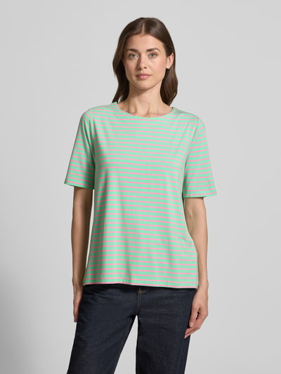 Frauenmodel trägt Relaxed Fit T-Shirt aus Viskose-Mix von Milano Italy, grün-gelb gestreift, Rundhalsausschnitt, Kurzarm, Ganzkörperansicht von vorne.