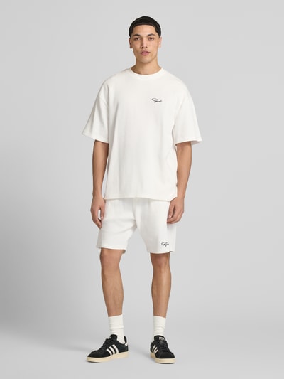 Männermodel trägt Oversized T-Shirt mit Strukturmuster von Pegador, Baumwoll-Mix, Oversized-Fit, Rundhalsausschnitt, Logo-Stitching, Herren T-Shirt in hellem Ton, Rückenlänge bei Größe M: 71 cm, Ganzkörperansicht von vorne.
