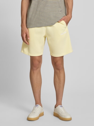 Männermodel trägt Pegador Relaxed Fit Shorts mit Strukturmuster Modell 'Lagos' in Gelb, elastischer Bund, Ganzkörperansicht von vorne.
