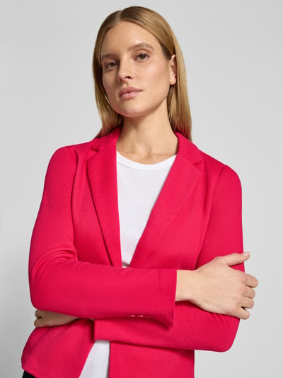 Modelka nosi Regular Fit Kurzblazer mit Baumwoll-Anteil Modell 'JULIA' od Vero Moda, gładki różowy piqué, kołnierz z klapami, długi rękaw, przód, zbliżenie na górę ciała.