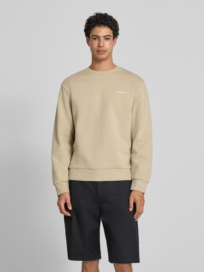 Männermodel trägt Sweatshirt mit Rundhalsausschnitt und Label-Stitching von Carhartt Work In Progress, beige, Baumwoll-Elasthan-Mix, Regular-Fit, Ganzkörperansicht von vorne.