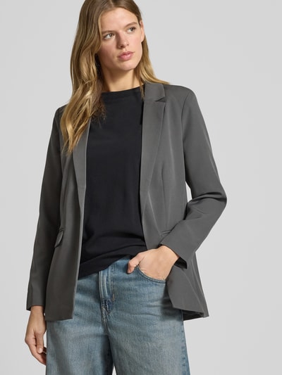 Frauenmodel trägt Blazer mit Reverskragen Modell 'Bossy' von PIECES aus Materialmischung mit Stretch-Anteil in Grau, lockerer Schnitt, Pattentaschen, leichtes Futter, Ganzkörperansicht von vorne.