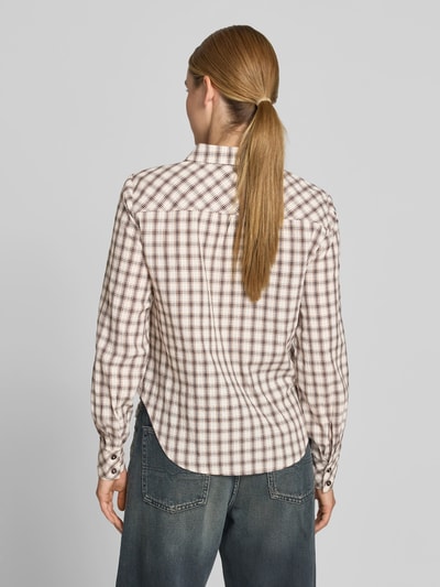 Frauenmodel trägt Hemdbluse mit Logo-Stitching von BAUM & PFERDGARTEN im karierten Baumwoll-Mix mit taillierter Passform, Rückenlänge 63 cm, Ganzkörperansicht Rückansicht.