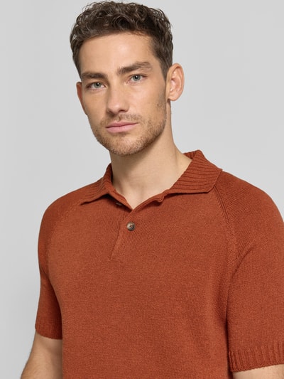 Męski model nosi Regular Fit Poloshirt aus Baumwoll-Kaschmir-Mix mit Knopfleiste od GRAN SASSO, ceglany odcień, mieszanka bawełny i kaszmiru, krój regular fit, listwa guzikowa, długość tyłu w rozmiarze 50: 68 cm, zbliżenie na górną część ciała.
