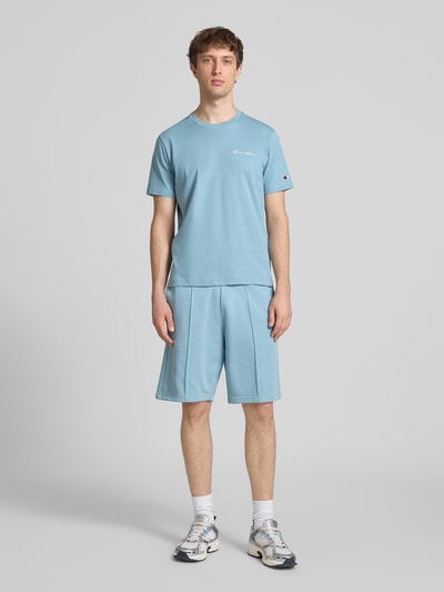Męski model nosi T-Shirt mit Label-Stitchings und Rundhalsausschnitt von CHAMPION, bawełna, krój regular fit, długość tyłu 69 cm, Ganzkörperansicht z przodu