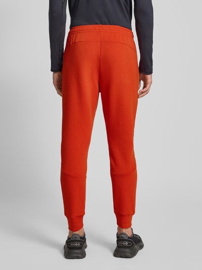 Under Armour Spodnie dresowe o kroju slim fit z nadrukiem z logo model ‘Unstoppable’ Jasnoczerwony 5