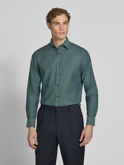 Männermodel trägt Modern Fit Businesshemd aus reiner Baumwolle von OLYMP, grün, glatte Textur, Ganzkörperansicht von vorne, Herren Businesshemd von OLYMP.