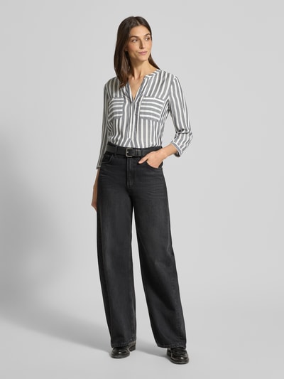 Modelka kobieca nosi Blusenshirt mit Streifenmuster od TOM TAILOR z czystej wiskozy, krój loose fit, wzór w paski, V-dekolt, kieszenie na biuście, rękawy 3/4, długość tyłu w rozmiarze 36: 66 cm, długość rękawa w rozmiarze 36: 50 cm, całe ciało z przodu.