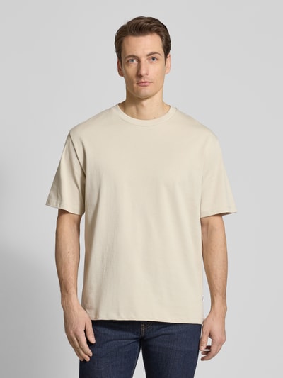 Männermodel trägt Oversized T-Shirt mit Rundhalsausschnitt von Lindbergh in Beige, reine Baumwolle, glatte Textur, Ganzkörperansicht von vorne.