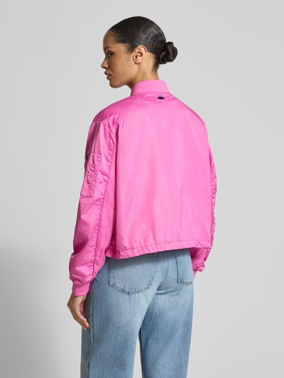 Frauenmodel trägt Boxy Fit Jacke mit Zweiwege-Reißverschluss Modell 'JODY' von Beaumont Amsterdam in kräftigem Pink, glatte Textur, Stehkragen, Eingrifftaschen, Rückenansicht, Ganzkörperansicht Rückansicht.