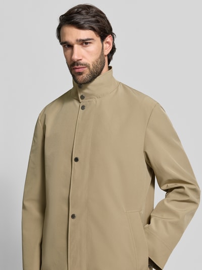 Männermodel trägt Regular Fit Mantel mit Stehkragen von Christian Berg Men, Beige, Eingrifftaschen, Elastischer-Material-Mix, Nahaufnahme Oberkörper.